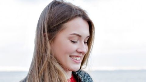 Picture of a smiling woman holding a smartphone